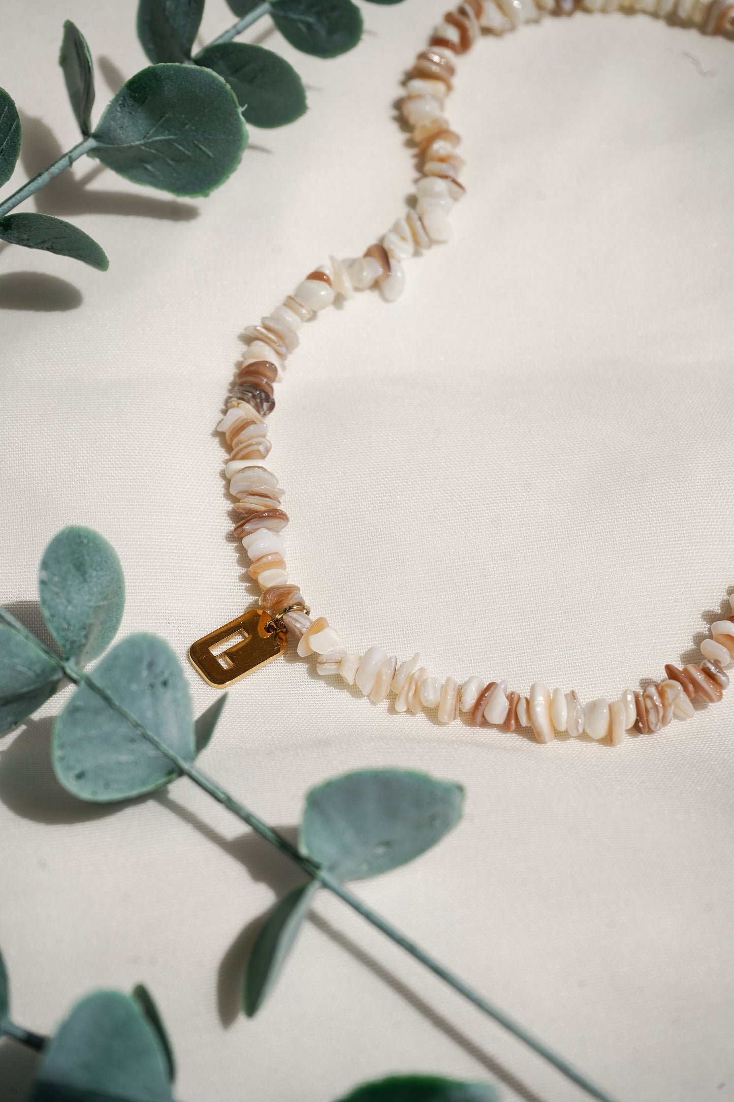 Colar de pedras e conchas com inicial